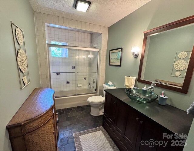 67 Cliffview Dr, Asheville, NC 28803 - full bath featuring vanity, toilet, enclosed tub / shower combo, a textured ceiling, and stone finish flooring