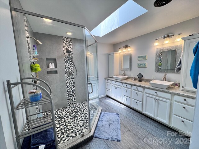 67 Cliffview Dr, Asheville, NC 28803 - bathroom featuring a stall shower, double vanity, a skylight, and baseboards