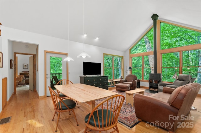 608 Brandywine Rd, Waynesville, NC 28786 - living area featuring a wood stove, high vaulted ceiling, plenty of natural light, and light wood-style flooring