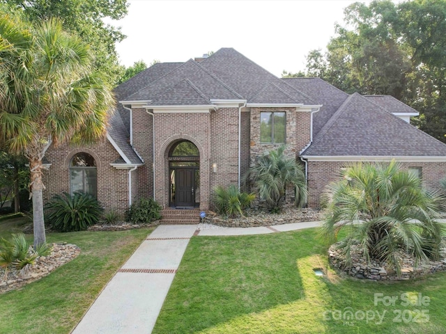 15708 Eagleview Dr, Charlotte, NC 28278 - traditional-style home with roof with shingles, a front lawn, and brick siding