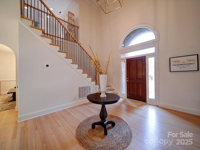 15708 Eagleview Dr, Charlotte, NC 28278 - entrance foyer with a high ceiling, stairs, arched walkways, wood finished floors, and baseboards