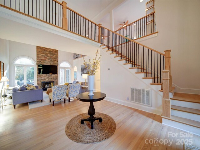 15708 Eagleview Dr, Charlotte, NC 28278 - living area featuring stairway, wood finished floors, a high ceiling, a stone fireplace, and baseboards