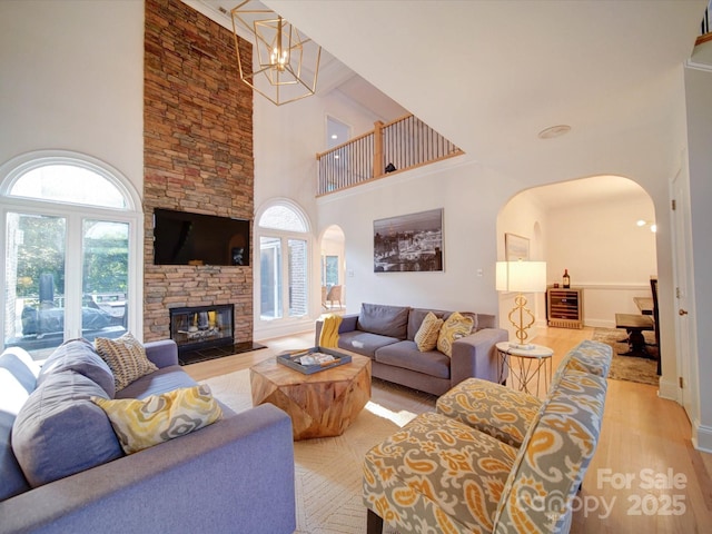 15708 Eagleview Dr, Charlotte, NC 28278 - living room featuring arched walkways, a towering ceiling, wood finished floors, and healthy amount of natural light