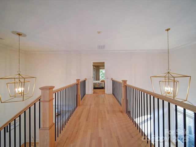 15708 Eagleview Dr, Charlotte, NC 28278 - hallway featuring a chandelier, an upstairs landing, light wood-style flooring, and ornamental molding