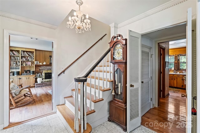 6434 Sardis Rd, Charlotte, NC 28270 - stairs featuring ornamental molding, a chandelier, a glass covered fireplace, and wood finished floors