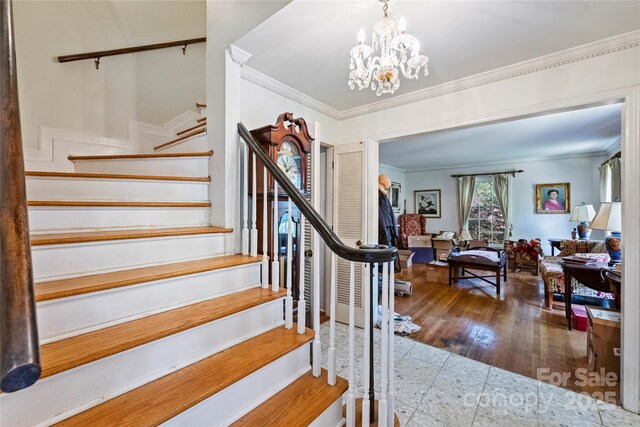 6434 Sardis Rd, Charlotte, NC 28270 - stairway featuring ornamental molding, a chandelier, and wood finished floors
