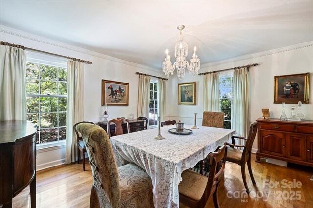 6434 Sardis Rd, Charlotte, NC 28270 - dining area with a chandelier, light wood-style floors, crown molding, and baseboards