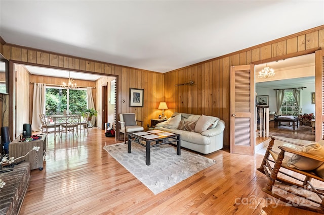 6434 Sardis Rd, Charlotte, NC 28270 - living area featuring a chandelier, wood walls, crown molding, and light wood finished floors
