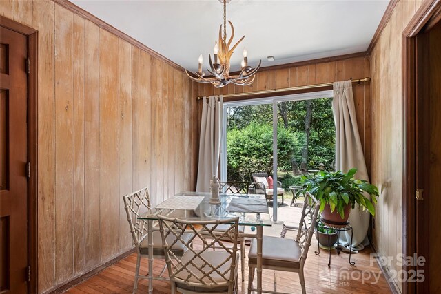 6434 Sardis Rd, Charlotte, NC 28270 - dining space with wooden walls, a chandelier, wood-type flooring, and crown molding