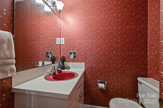 6434 Sardis Rd, Charlotte, NC 28270 - bathroom featuring vanity, wallpapered walls, toilet, a chandelier, and baseboards