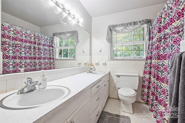 6434 Sardis Rd, Charlotte, NC 28270 - full bath with tile walls, double vanity, tile patterned floors, toilet, and wainscoting