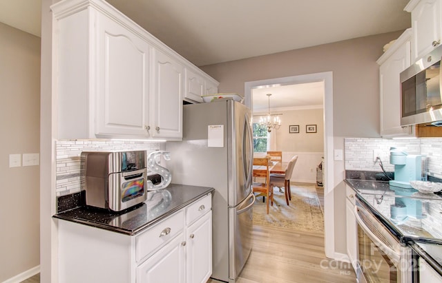 110 Spring Path, Hendersonville, NC 28739 - kitchen with stainless steel appliances, light wood-type flooring, white cabinetry, a chandelier, and ornamental molding