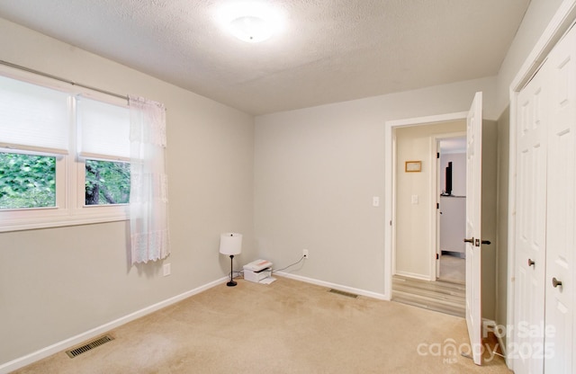 110 Spring Path, Hendersonville, NC 28739 - spare room featuring light colored carpet, baseboards, and a textured ceiling