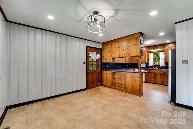 191 Rolling Green Dr, Sylva, NC 28779 - kitchen featuring a peninsula, freestanding refrigerator, brown cabinets, dark countertops, and recessed lighting