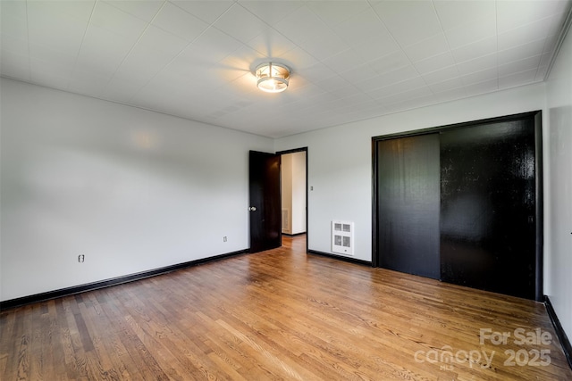 191 Rolling Green Dr, Sylva, NC 28779 - unfurnished bedroom featuring wood finished floors, baseboards, a closet, and heating unit