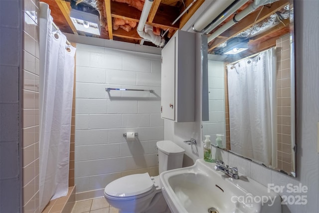191 Rolling Green Dr, Sylva, NC 28779 - bathroom featuring toilet, curtained shower, a sink, concrete block wall, and tile patterned floors