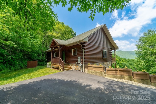 938 Trickle Creek Rd, Waynesville, NC 28785 - log cabin featuring log siding, a porch, asphalt driveway, and a front lawn