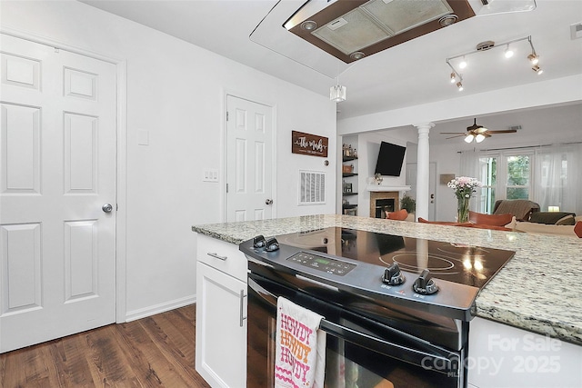 433 W 8th St Unit 66, Charlotte, NC 28202 - kitchen with black range with electric stovetop, decorative columns, a fireplace, dark wood-style flooring, and white cabinets