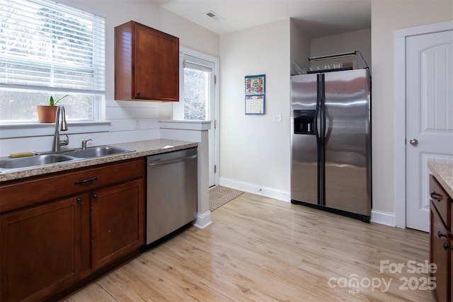 15907 Rose Glenn Ln, Davidson, NC 28036 - kitchen with stainless steel appliances, a sink, light wood-style floors, and plenty of natural light