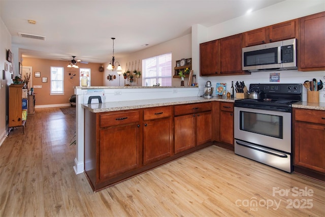 15907 Rose Glenn Ln, Davidson, NC 28036 - kitchen featuring appliances with stainless steel finishes, a peninsula, light wood finished floors, and plenty of natural light