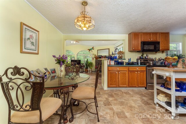 38 Hidden Forest Dr, Hendersonville, NC 28792 - kitchen with stainless steel electric range, black microwave, brown cabinetry, dark countertops, and a chandelier