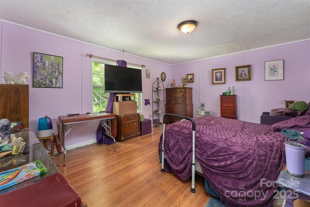 38 Hidden Forest Dr, Hendersonville, NC 28792 - bedroom featuring a textured ceiling, light wood-style floors, and ornamental molding