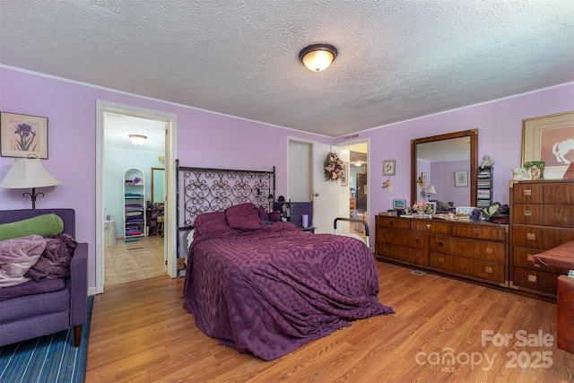 38 Hidden Forest Dr, Hendersonville, NC 28792 - bedroom featuring light wood-style flooring, ornamental molding, and a textured ceiling