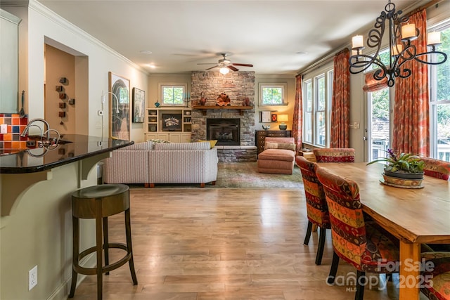 7 White Palmer Ct, Biltmore Lake, NC 28715 - dining area featuring ceiling fan, wood finished floors, ornamental molding, a chandelier, and a stone fireplace
