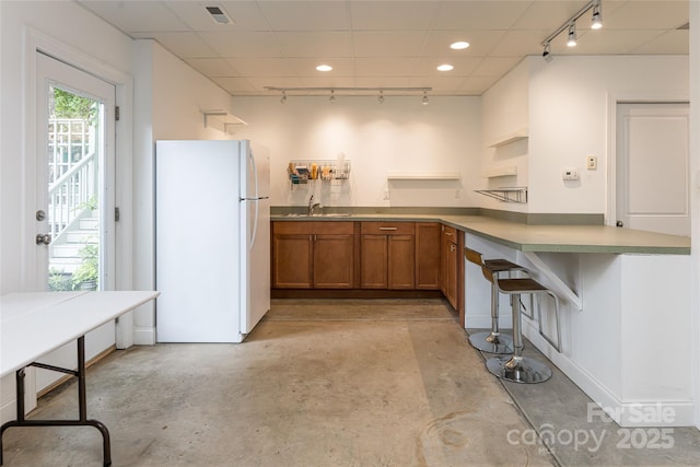 7 White Palmer Ct, Biltmore Lake, NC 28715 - kitchen with freestanding refrigerator, track lighting, brown cabinetry, concrete floors, and recessed lighting