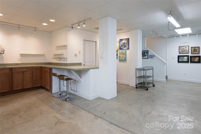 7 White Palmer Ct, Biltmore Lake, NC 28715 - kitchen with brown cabinets, track lighting, concrete floors, open shelves, and a paneled ceiling