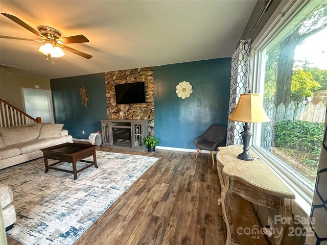 156 Spruce St, Badin, NC 28009 - living room with wood finished floors, a ceiling fan, baseboards, and a stone fireplace