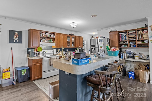 8650 Lambs Way, Connelly Springs, NC 28612 - kitchen with stainless steel fridge, electric stove, brown cabinetry, light countertops, and crown molding