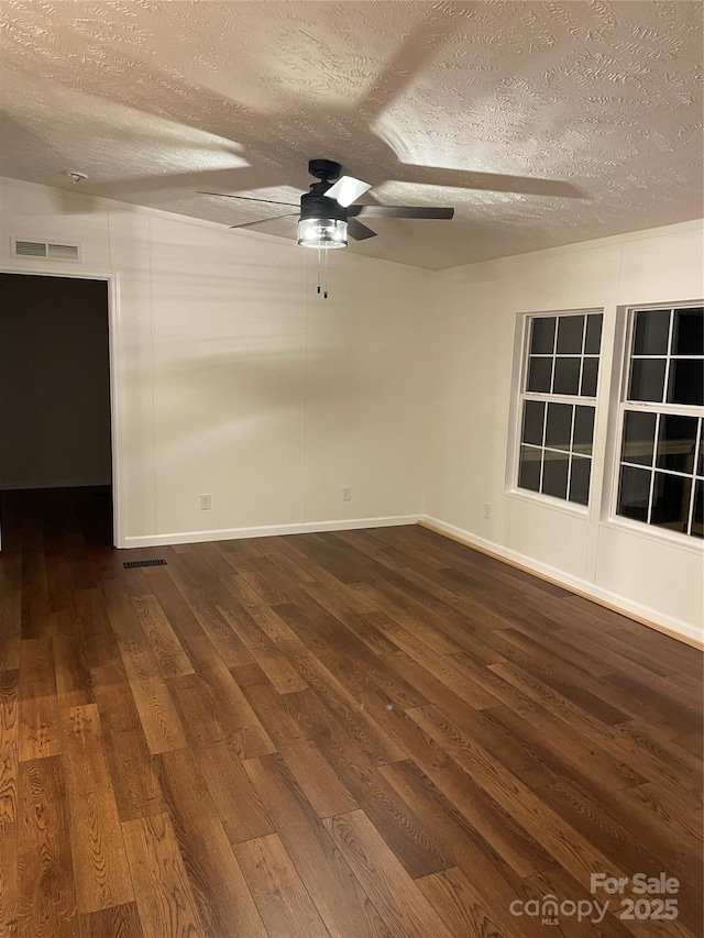 6219 Heavner Rd, Vale, NC 28168 - spare room with dark wood-style flooring, a textured ceiling, ceiling fan, and baseboards