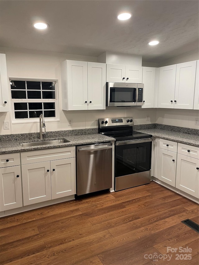 6219 Heavner Rd, Vale, NC 28168 - kitchen with appliances with stainless steel finishes, a sink, white cabinetry, recessed lighting, and dark wood-style flooring