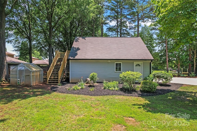 18733 Bluff Point Rd, Cornelius, NC 28031 - view of home's exterior with a greenhouse, a lawn, an outdoor structure, stairs, and a shingled roof