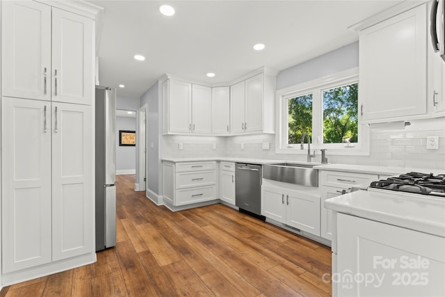 18733 Bluff Point Rd, Cornelius, NC 28031 - kitchen with stainless steel appliances, decorative backsplash, white cabinetry, and recessed lighting