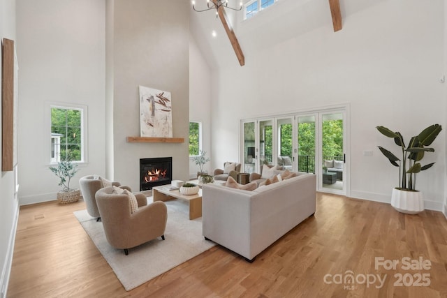 213 Crest Ct, Weddington, NC 28104 - living room with high vaulted ceiling, a glass covered fireplace, light wood finished floors, plenty of natural light, and baseboards