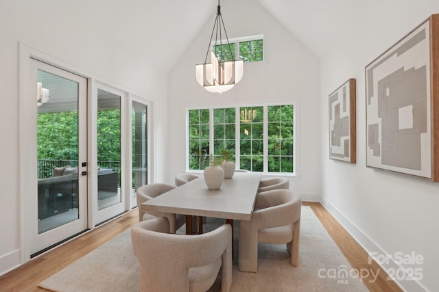 213 Crest Ct, Weddington, NC 28104 - dining area with light wood-style floors, healthy amount of natural light, a chandelier, and high vaulted ceiling