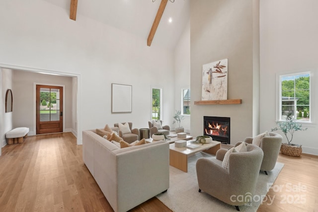 213 Crest Ct, Weddington, NC 28104 - living area with high vaulted ceiling, light wood-style flooring, a glass covered fireplace, beamed ceiling, and baseboards