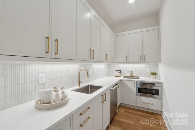 213 Crest Ct, Weddington, NC 28104 - kitchen featuring a sink, tasteful backsplash, light wood finished floors, and appliances with stainless steel finishes