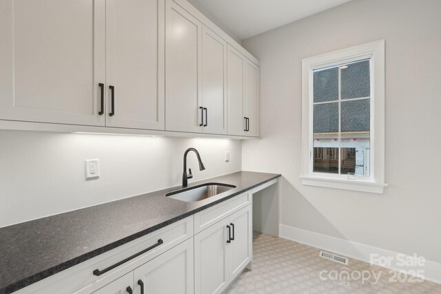 213 Crest Ct, Weddington, NC 28104 - kitchen with a sink, baseboards, light floors, and white cabinetry