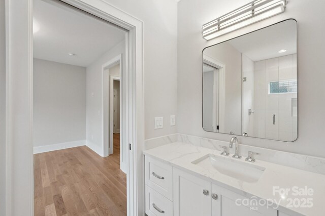 213 Crest Ct, Weddington, NC 28104 - full bathroom with vanity, wood finished floors, a stall shower, and baseboards