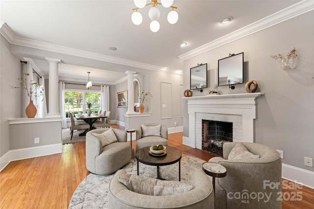 901 Hartford Ave, Charlotte, NC 28209 - living area with ornate columns, light wood-type flooring, ornamental molding, baseboards, and a brick fireplace