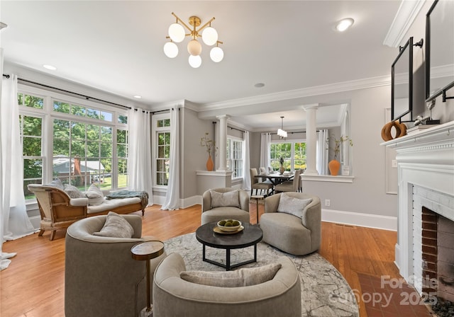 901 Hartford Ave, Charlotte, NC 28209 - living room featuring ornamental molding, ornate columns, light wood finished floors, a chandelier, and baseboards
