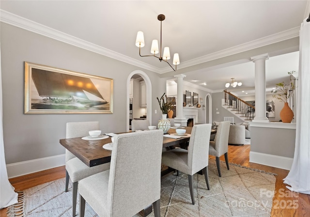 901 Hartford Ave, Charlotte, NC 28209 - dining area with decorative columns, wood finished floors, crown molding, baseboards, and arched walkways