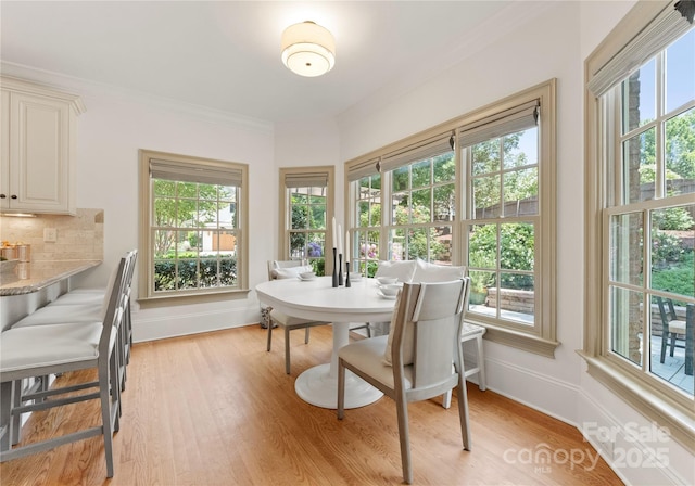 901 Hartford Ave, Charlotte, NC 28209 - dining space featuring baseboards, light wood-style floors, and ornamental molding