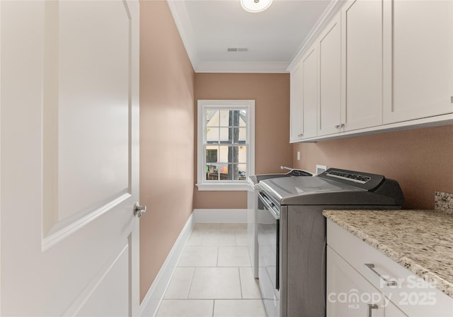 901 Hartford Ave, Charlotte, NC 28209 - laundry area with separate washer and dryer, cabinet space, baseboards, ornamental molding, and light tile patterned floors