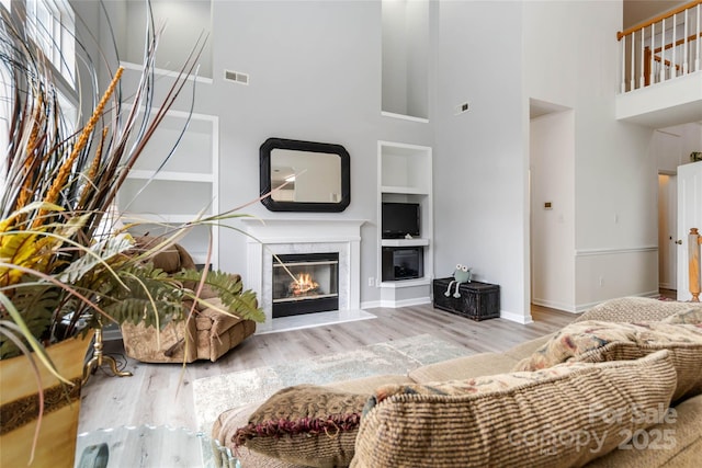 7704 Ninth Fairway Ln, Mint Hill, NC 28227 - living area with a high ceiling, wood finished floors, built in shelves, and a premium fireplace