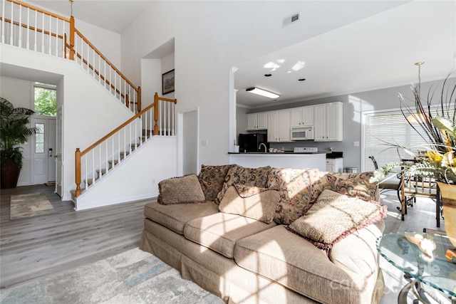 7704 Ninth Fairway Ln, Mint Hill, NC 28227 - living room with stairs, light wood finished floors, and a high ceiling