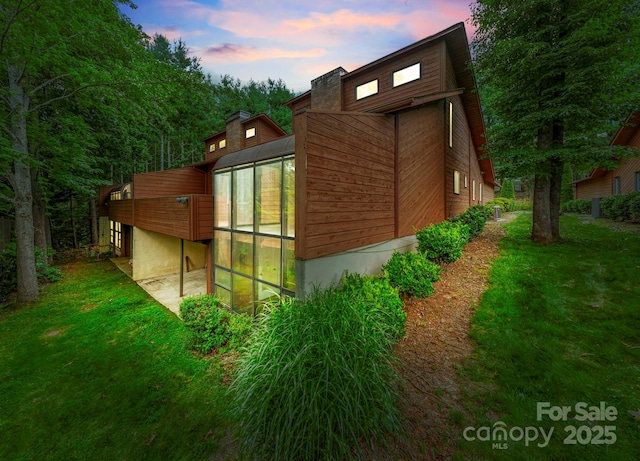 204 Woodfield Dr, Asheville, NC 28803 - view of home's exterior featuring a lawn and a sunroom